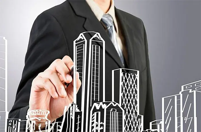 Ejecutivo - Profesional trazando una visión estratégica de crecimiento urbano o desarrollo corporativo mediante un bosquejo de ciudad.